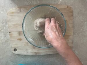 Crunchy Tasty AIP Crackers dough being shaped by hand in a glass bowl – cassava-free, gluten-free, paleo, autoimmune protocol friendly.
