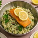 AIP Creamy Mushroom Risotto with salmon served in a stainless steel casserole, topped with lemon slices and parsley, grain free dairy free recipe
