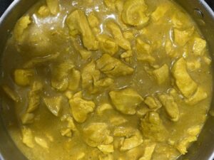 Chicken simmering in coconut milk, bone broth, turmeric, and spices for AIP Thai Coconut Chicken.