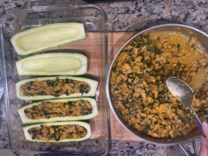Stuffing zucchini shells with turkey, kale, and vegetable filling for AIP Zucchini Boats, gluten free, dairy free, and nightshades free.