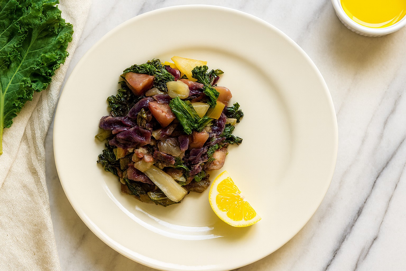 Rainbow Veggie Stew served on a cream plate with kale, cabbage, parsnips, and a lemon wedge. AIP, anti-inflammatory, and gut-healing vegetable dish.
