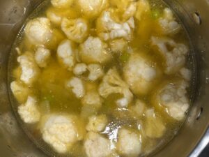 Cauliflower, carrots, celery, and garlic simmering in bone broth for AIP Cauliflower Cream Soup, a dairy free and anti-inflammatory recipe.