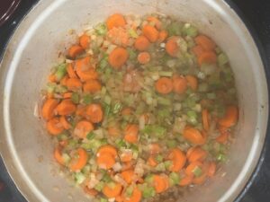 Carrots, celery, and onion sautéing in a pot for Best AIP Osso Buco.