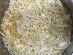 Cabbage and Potato Soup dairy free gluten free AIP-friendly with shredded cabbage simmering in pot of broth