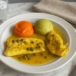 Healthiest AIP chicken piccata with bright carrot and asparagus purées, tender chicken in lemon caper sauce, served on a white plate for an autoimmune-friendly meal.