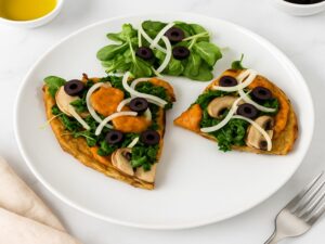 Tasty AIP Pizza Crust on marble table, topped with kale, mushrooms, and olives, served with a fresh salad — healthy, gluten-free, gut-friendly, and perfect for autoimmune diets.