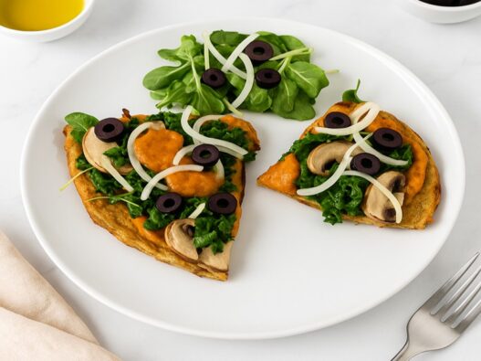Tasty AIP Pizza Crust on marble table, topped with kale, mushrooms, and olives, served with a fresh salad — healthy, gluten-free, gut-friendly, and perfect for autoimmune diets.